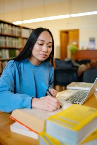 Student studying citation styles at university library UK